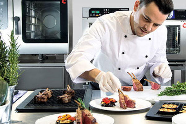 professionele kok die een bord opmaakt in de keuken